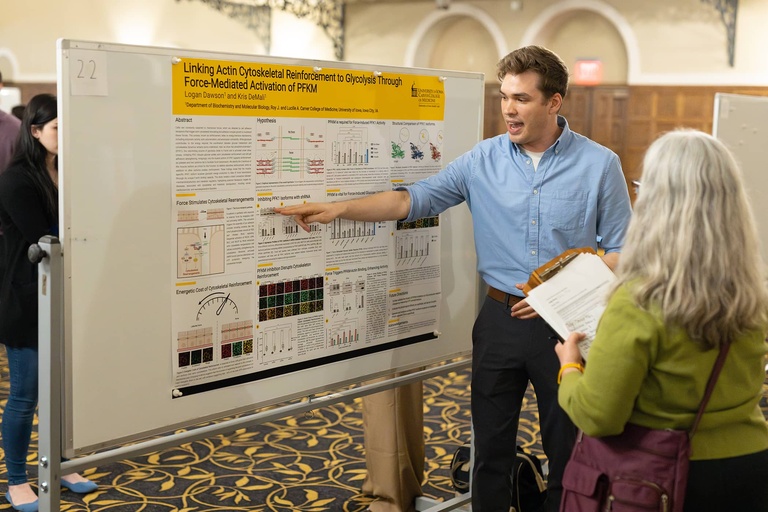 A graduate student presents his research to an interested attendee at the 2025 Jakobsen Conference.